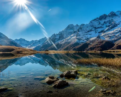 beautiful-shot-crystal-clear-lake-snowy-mountain-base-during-sunny-day_181624-5459